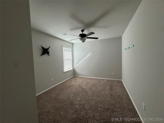 empty room with carpet flooring, ceiling fan, and a textured ceiling