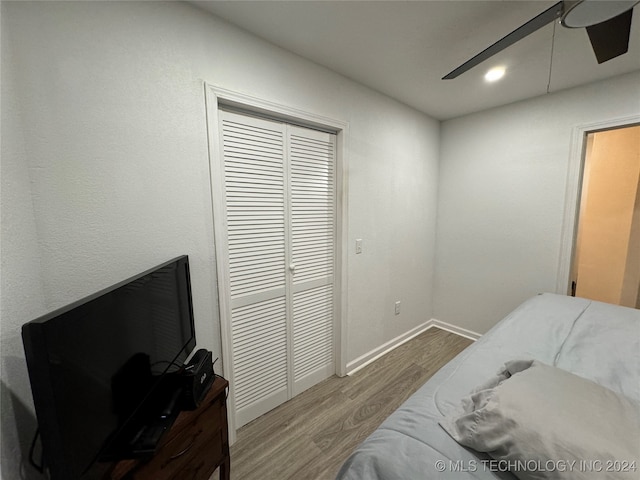 bedroom with hardwood / wood-style floors, a closet, and ceiling fan