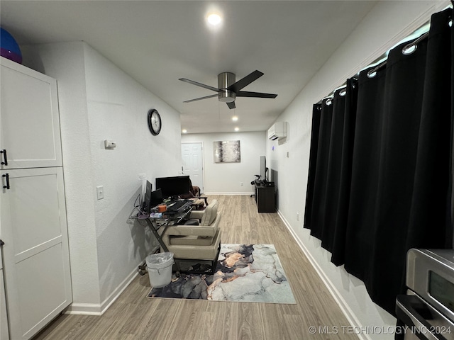 interior space with light hardwood / wood-style floors, a wall unit AC, and ceiling fan