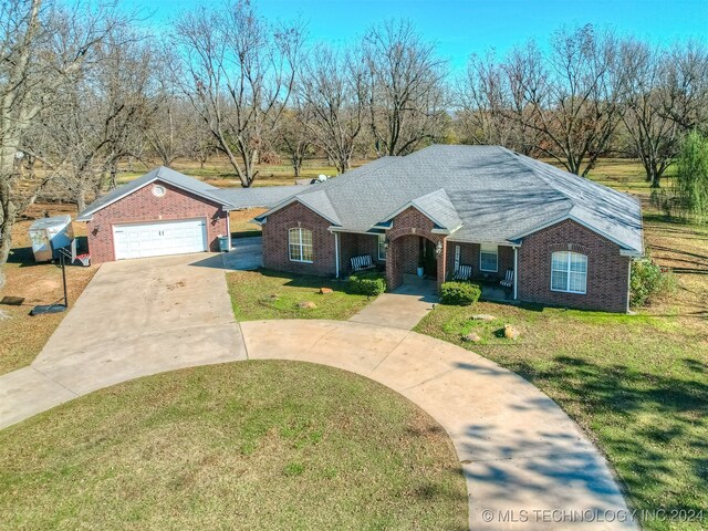 single story home with a front yard, a porch, and a garage