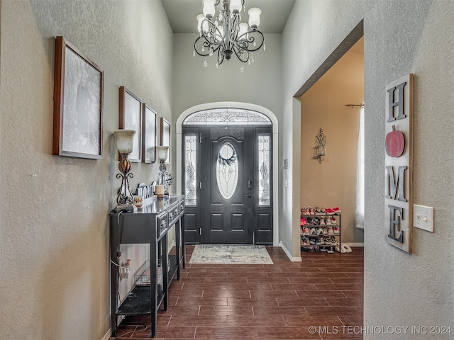 entryway with dark hardwood / wood-style floors and a notable chandelier