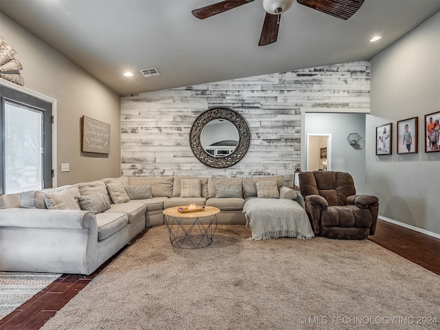 living room featuring vaulted ceiling, ceiling fan, and dark wood-type flooring