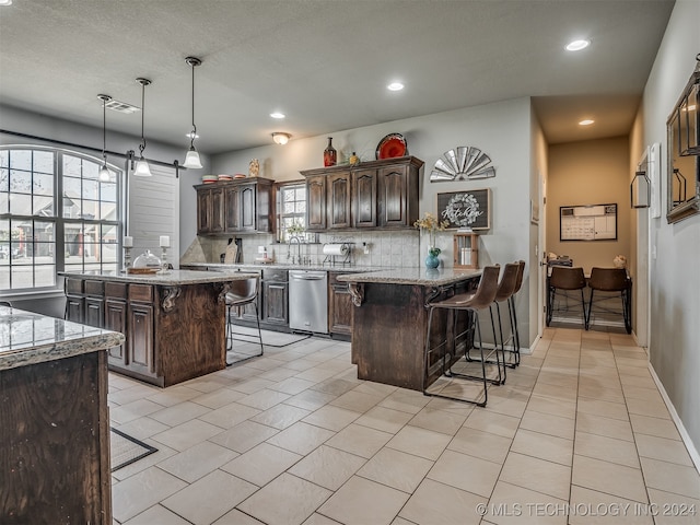 kitchen featuring a breakfast bar, dark brown cabinets, a center island, and dishwasher