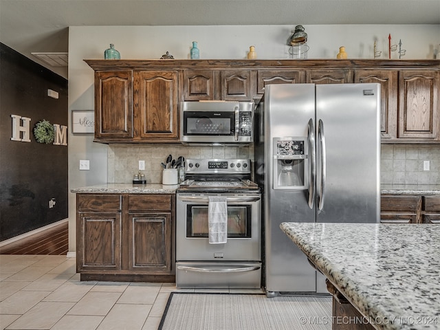 kitchen with dark brown cabinets, backsplash, and appliances with stainless steel finishes