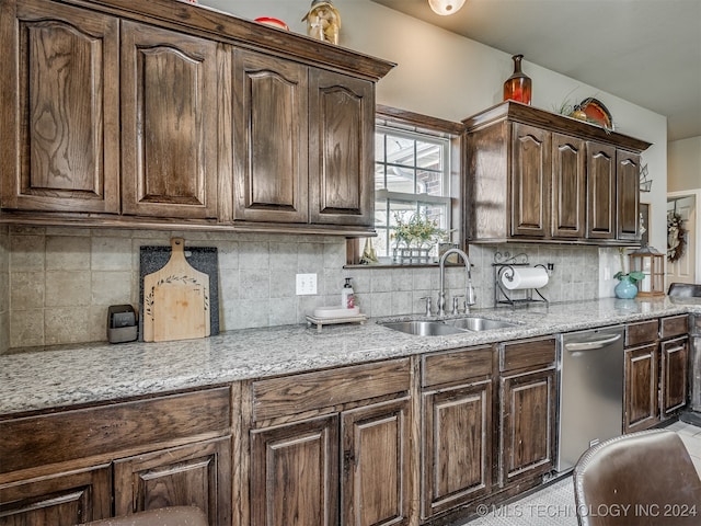 kitchen featuring sink, light stone counters, stainless steel dishwasher, decorative backsplash, and dark brown cabinets