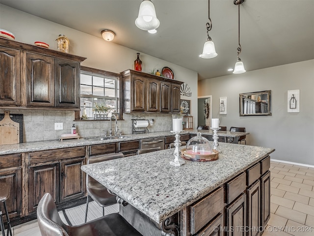 kitchen with backsplash, a center island, pendant lighting, and sink