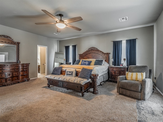 carpeted bedroom with ensuite bathroom and ceiling fan