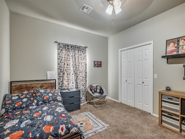 carpeted bedroom featuring ceiling fan and a closet