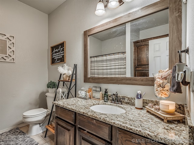 bathroom featuring toilet, vanity, tile patterned floors, and walk in shower