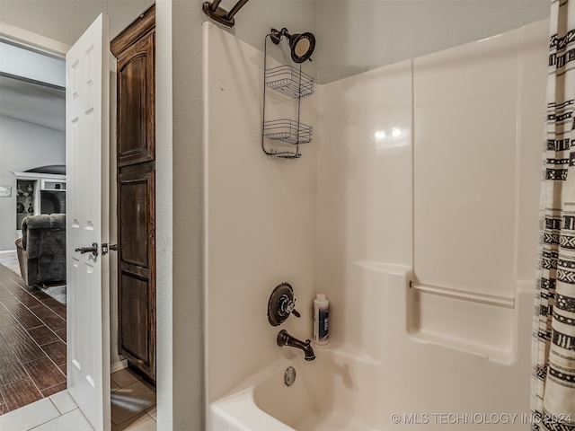 bathroom featuring wood-type flooring and shower / bath combo with shower curtain