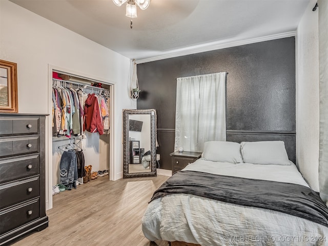 bedroom featuring ceiling fan, a closet, light hardwood / wood-style floors, and ornamental molding