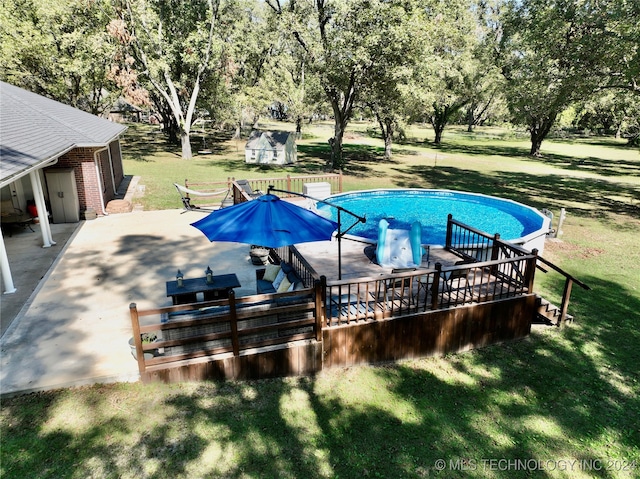 view of pool with a lawn and a deck