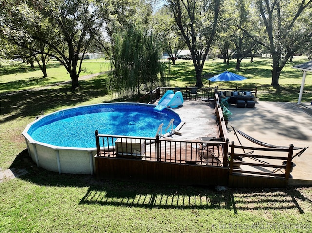 view of pool with a lawn