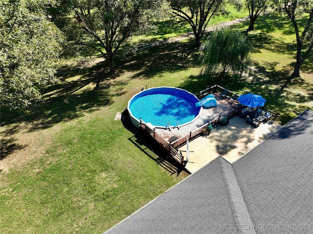 view of pool with a yard