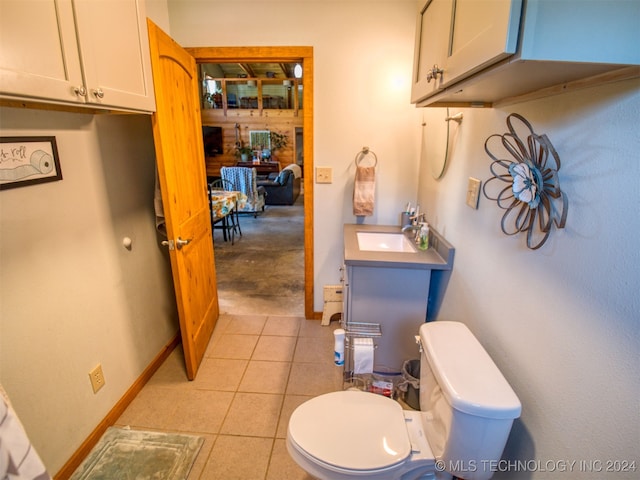 bathroom with toilet, vanity, and tile patterned floors