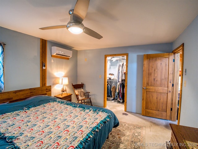 carpeted bedroom with a walk in closet, ceiling fan, a closet, and a wall mounted AC