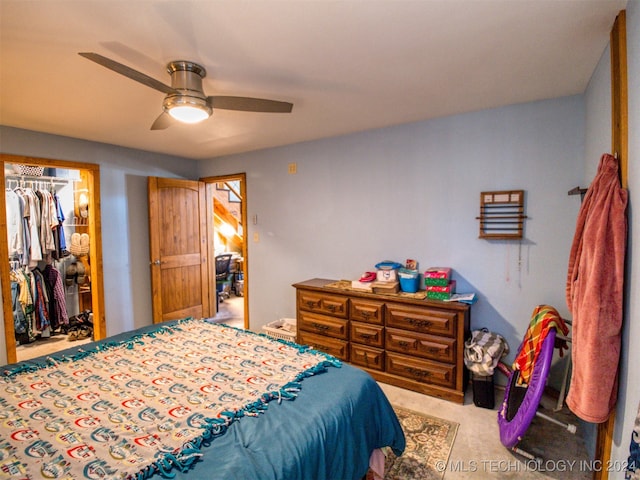 bedroom with ceiling fan, light colored carpet, and a closet