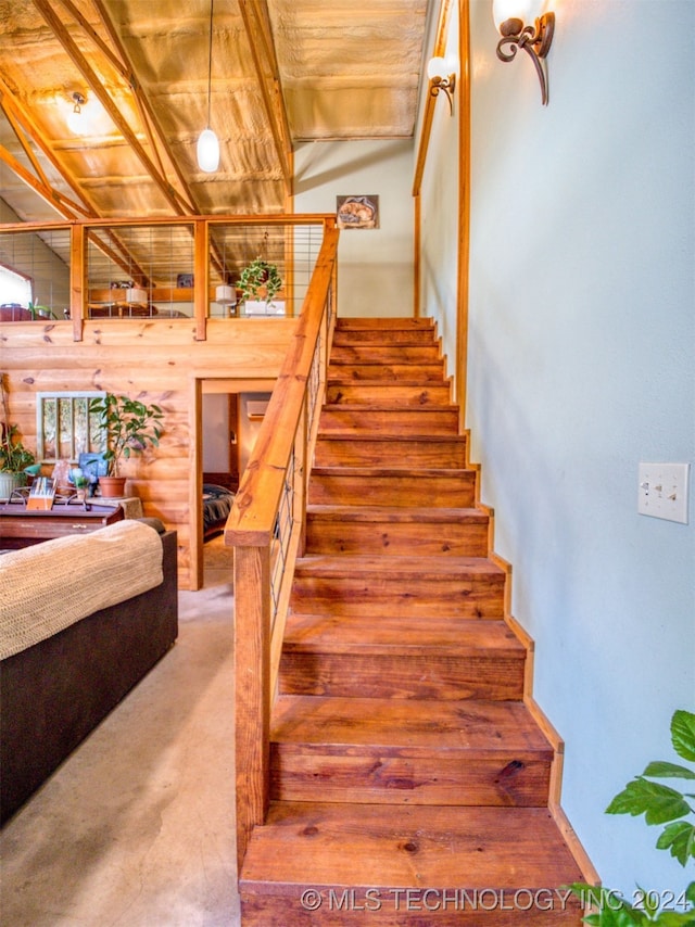 stairs featuring vaulted ceiling and wooden ceiling