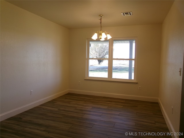 unfurnished room featuring dark hardwood / wood-style floors and a notable chandelier