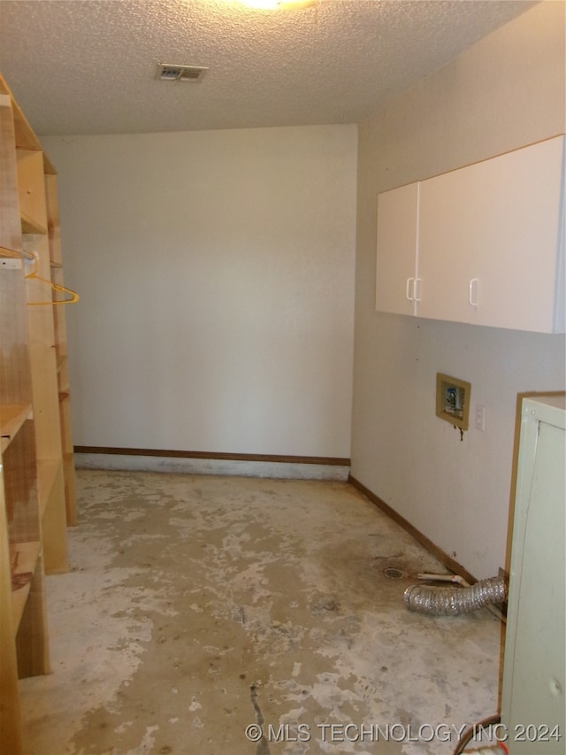 laundry area with cabinets, washer hookup, and a textured ceiling