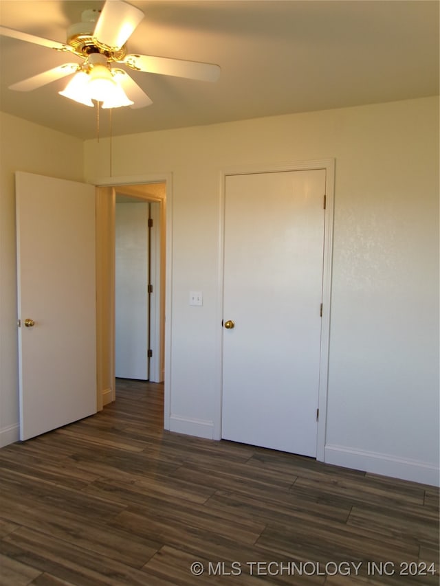 unfurnished bedroom with ceiling fan and dark hardwood / wood-style floors