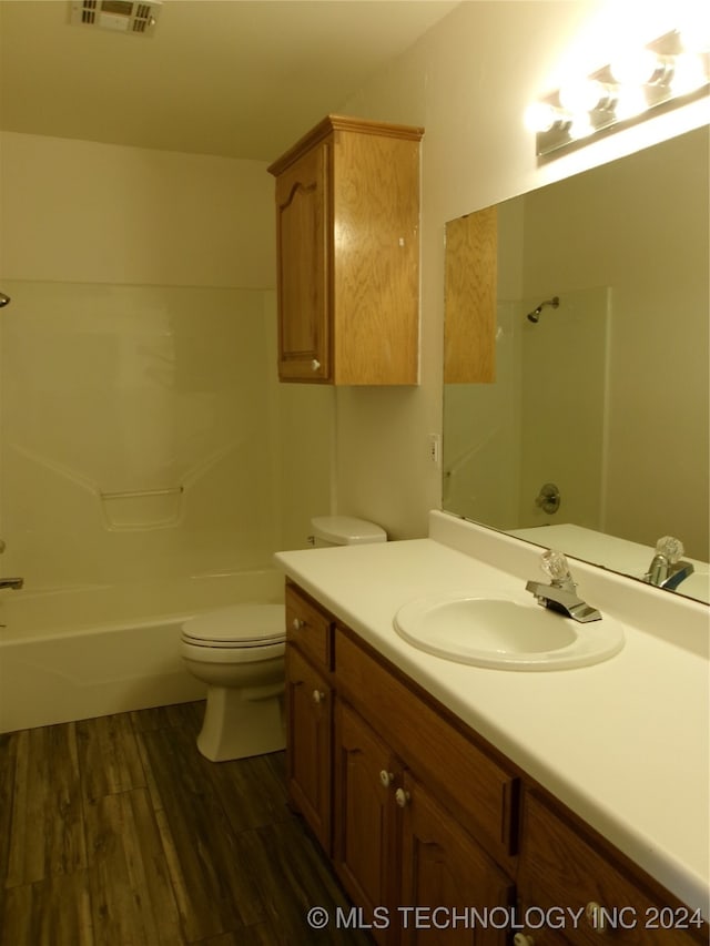 full bathroom featuring shower / bathing tub combination, vanity, hardwood / wood-style flooring, and toilet