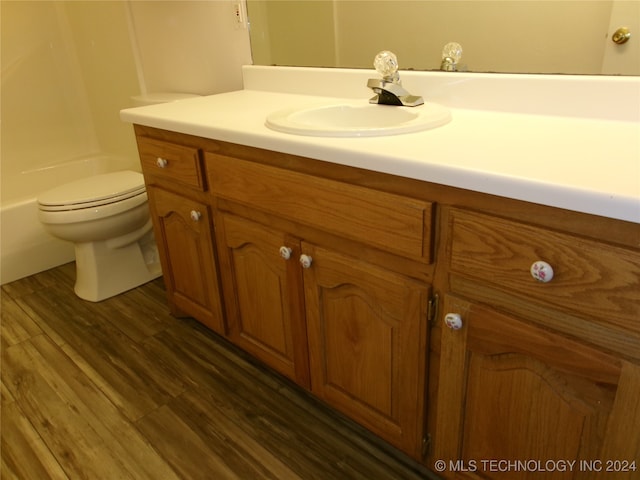 bathroom with hardwood / wood-style flooring, vanity, and toilet