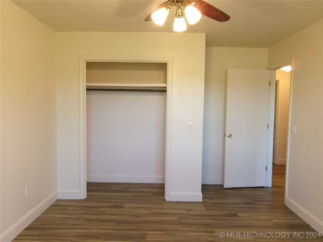 unfurnished bedroom featuring ceiling fan, dark hardwood / wood-style flooring, and a closet