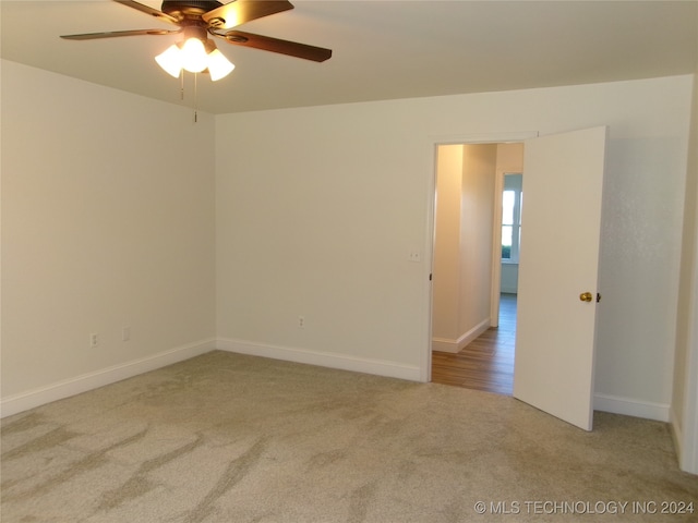 carpeted spare room with ceiling fan