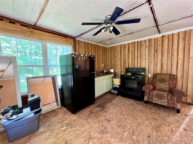 kitchen with ceiling fan, white cabinets, black appliances, and wood walls