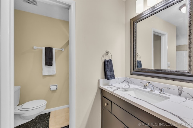 bathroom with tile patterned flooring, vanity, and toilet