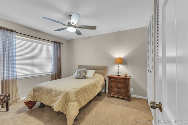 carpeted bedroom with ceiling fan and a closet