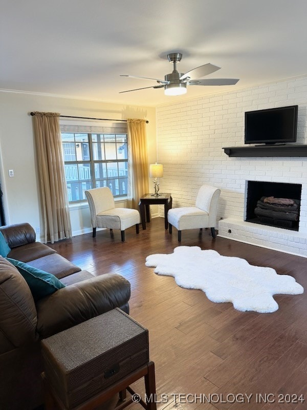 living room with ceiling fan, wood-type flooring, a fireplace, and brick wall