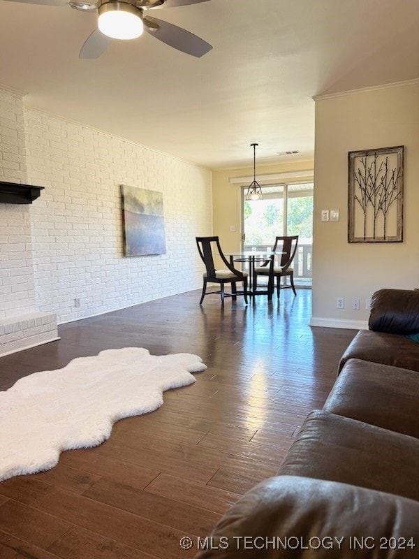 living room featuring ceiling fan, brick wall, and dark hardwood / wood-style floors