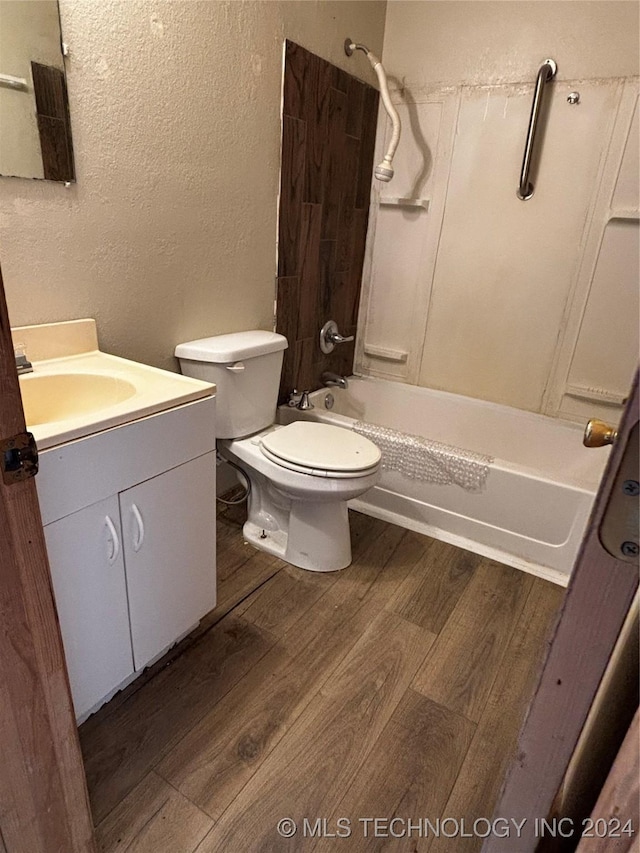 full bathroom featuring hardwood / wood-style floors, vanity, bathtub / shower combination, and toilet