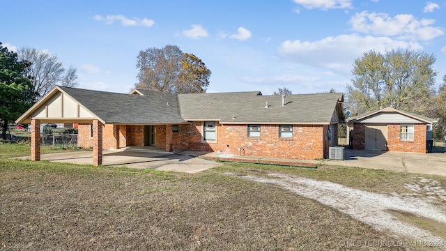 rear view of house with a yard, central AC, and a carport