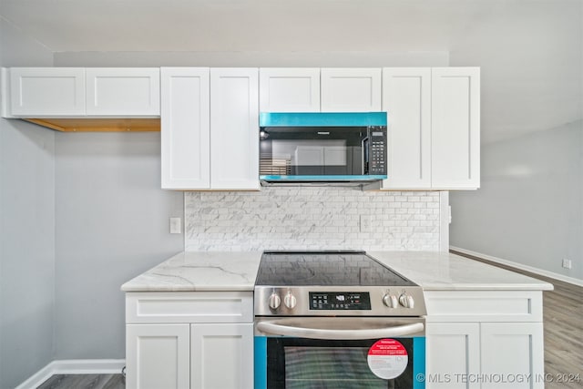 kitchen featuring light stone counters, white cabinets, and high end stainless steel range oven