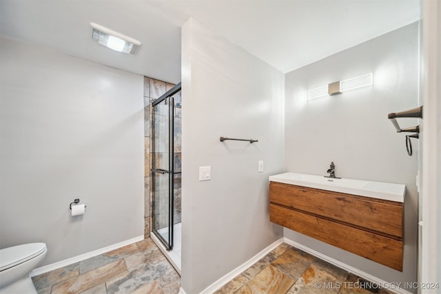 bathroom with a shower with door, vanity, and toilet