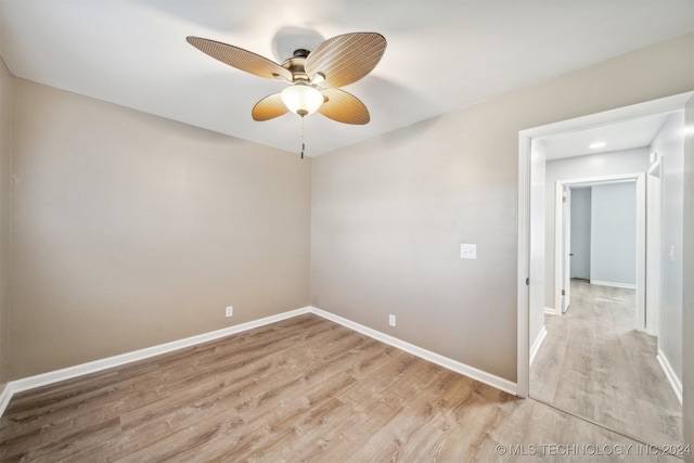 spare room with ceiling fan and light wood-type flooring