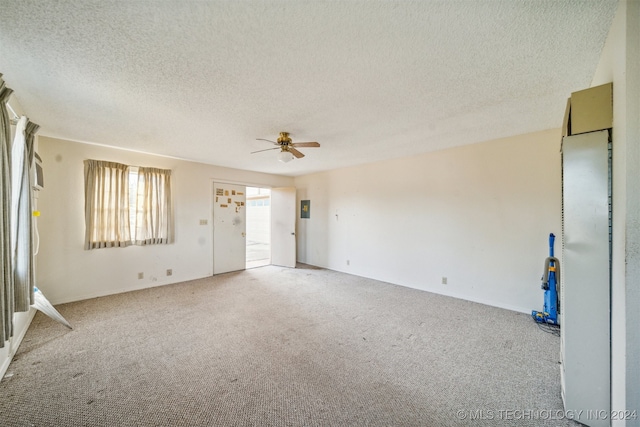 carpeted empty room with ceiling fan and a textured ceiling