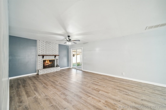 unfurnished living room featuring ceiling fan, light hardwood / wood-style floors, and a brick fireplace