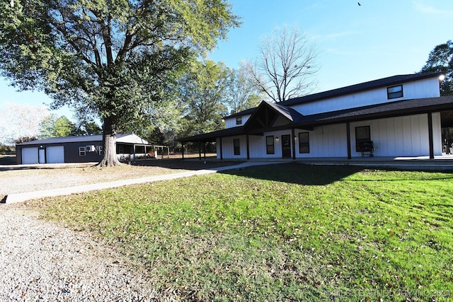 exterior space with a carport, a front yard, a garage, and an outdoor structure