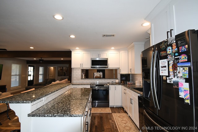 kitchen with dark wood-type flooring, stainless steel appliances, backsplash, white cabinets, and ceiling fan