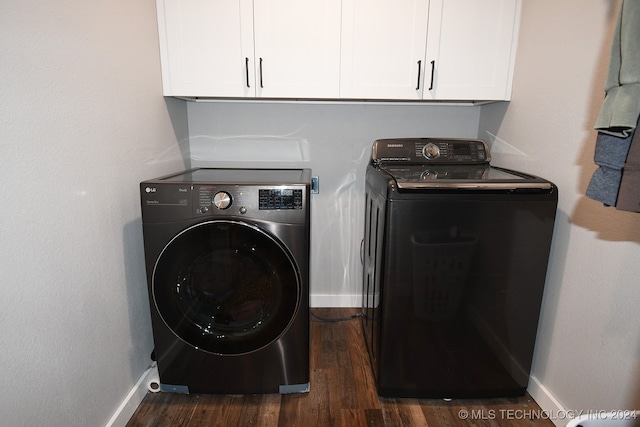 laundry room featuring independent washer and dryer, dark wood-type flooring, and cabinets