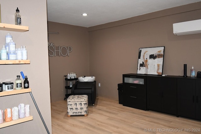 sitting room featuring an AC wall unit and light hardwood / wood-style floors