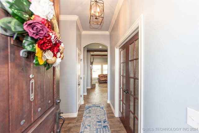 hallway featuring a chandelier, dark hardwood / wood-style flooring, and ornamental molding