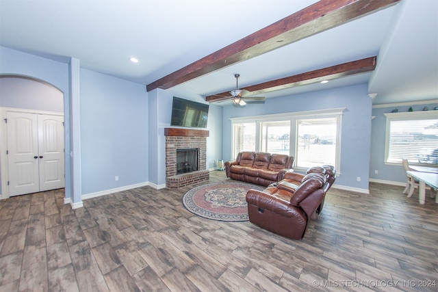 living room with a fireplace, hardwood / wood-style floors, ceiling fan, and beamed ceiling