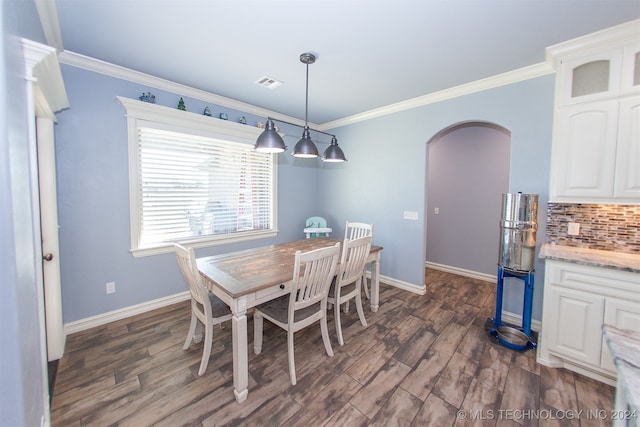 dining space with dark wood-type flooring and ornamental molding