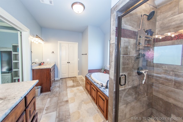 bathroom with vanity and shower with separate bathtub