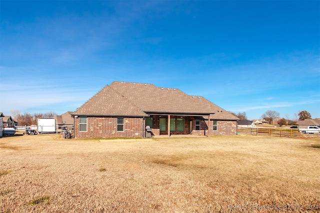 rear view of house featuring a lawn